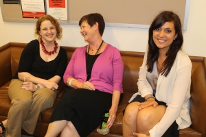 Members of the Office of Clinical and Pro Bono programs smile sitting on a couch.